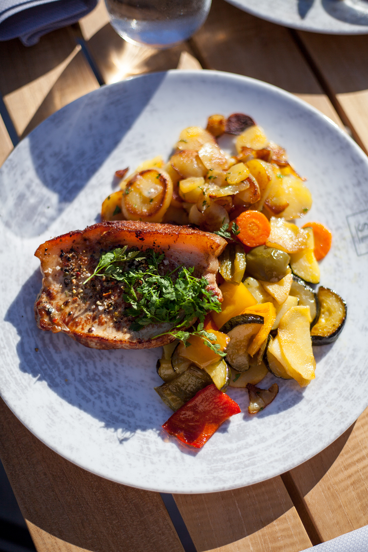 Ein Teller mit Fisch und Bratkartoffeln mit Gemüse