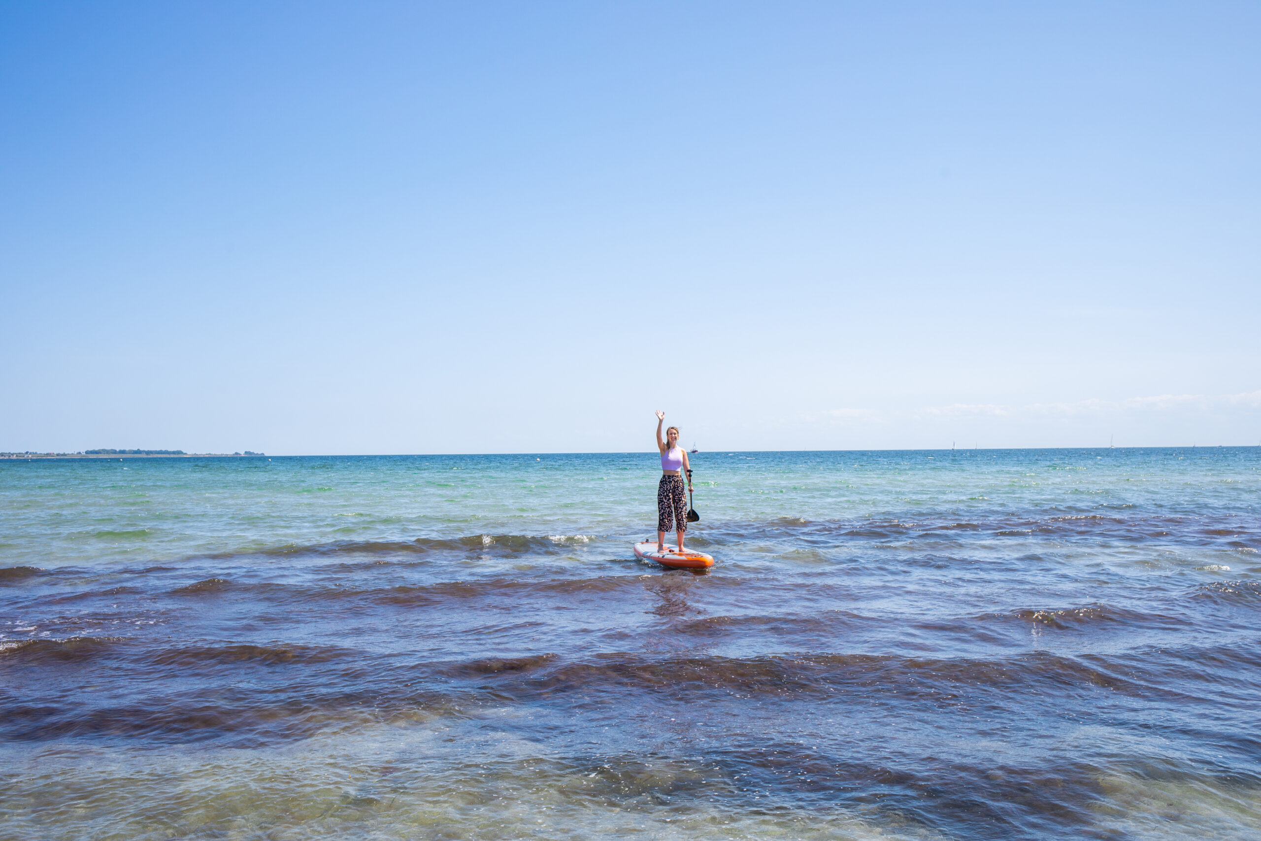 Finja steht auf einem SUP Board auf dem Wasser