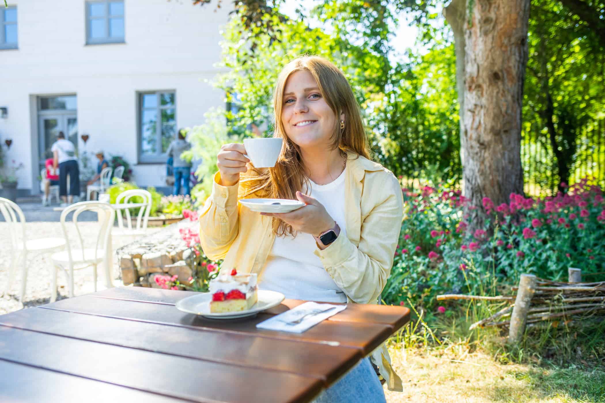 Maya trinkt einen Cappucchino im Hofcafé Albertsdorf