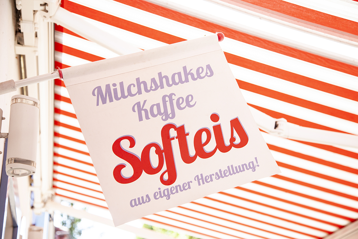 Eine Fahne mit der Aufschrift „Milchshakes, Kaffee, Softeis aus eigener Herstellung“