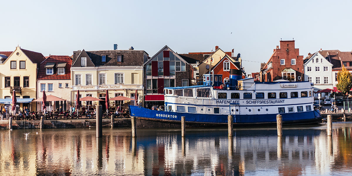 Ein Schiff im Husumer Hafen mit Häusern im Hintergrund