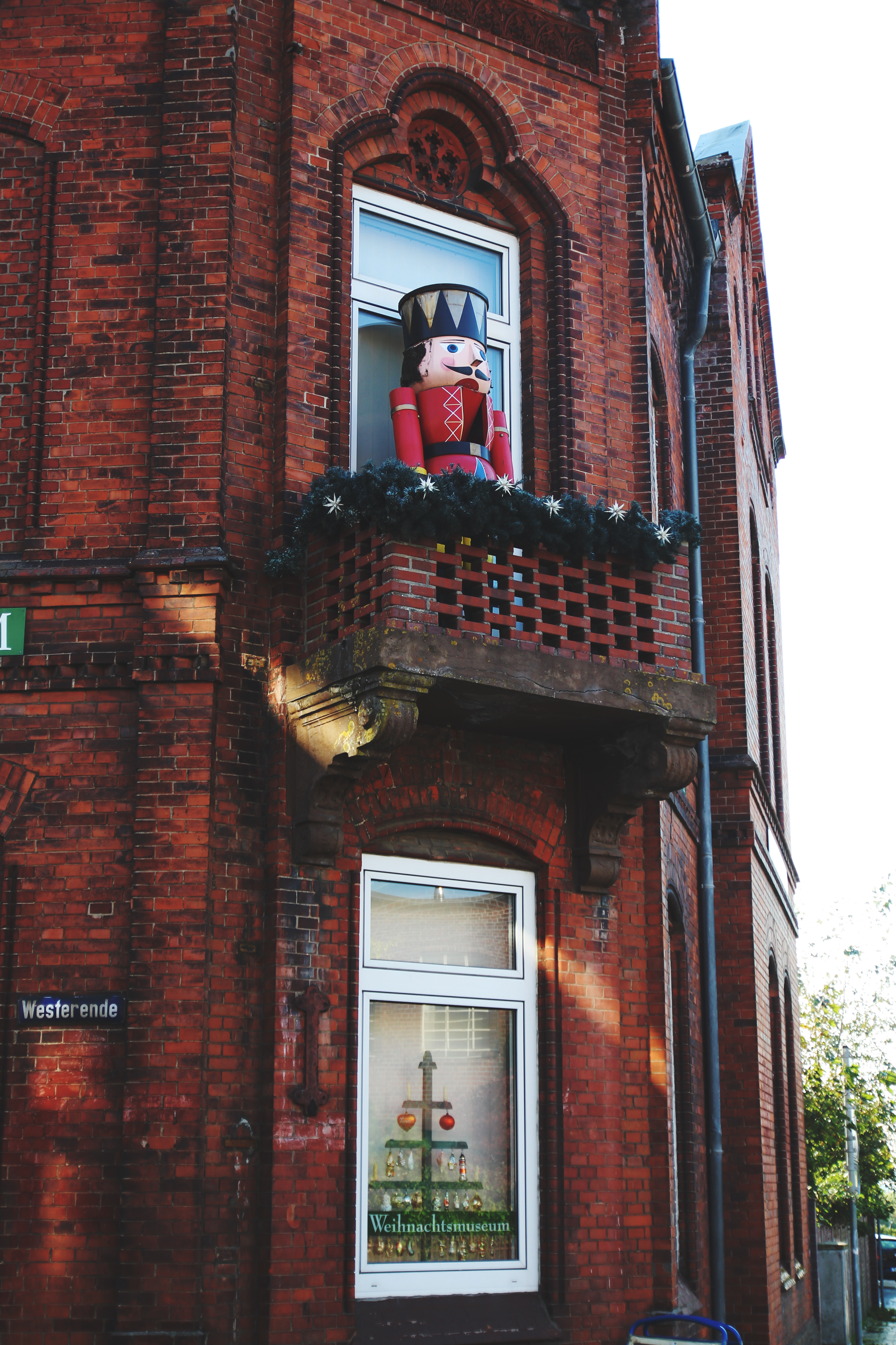 Die Außenfassade des Weihnachtshaus Husum mit einem großen Deko-Nussknacker auf dem Balkon