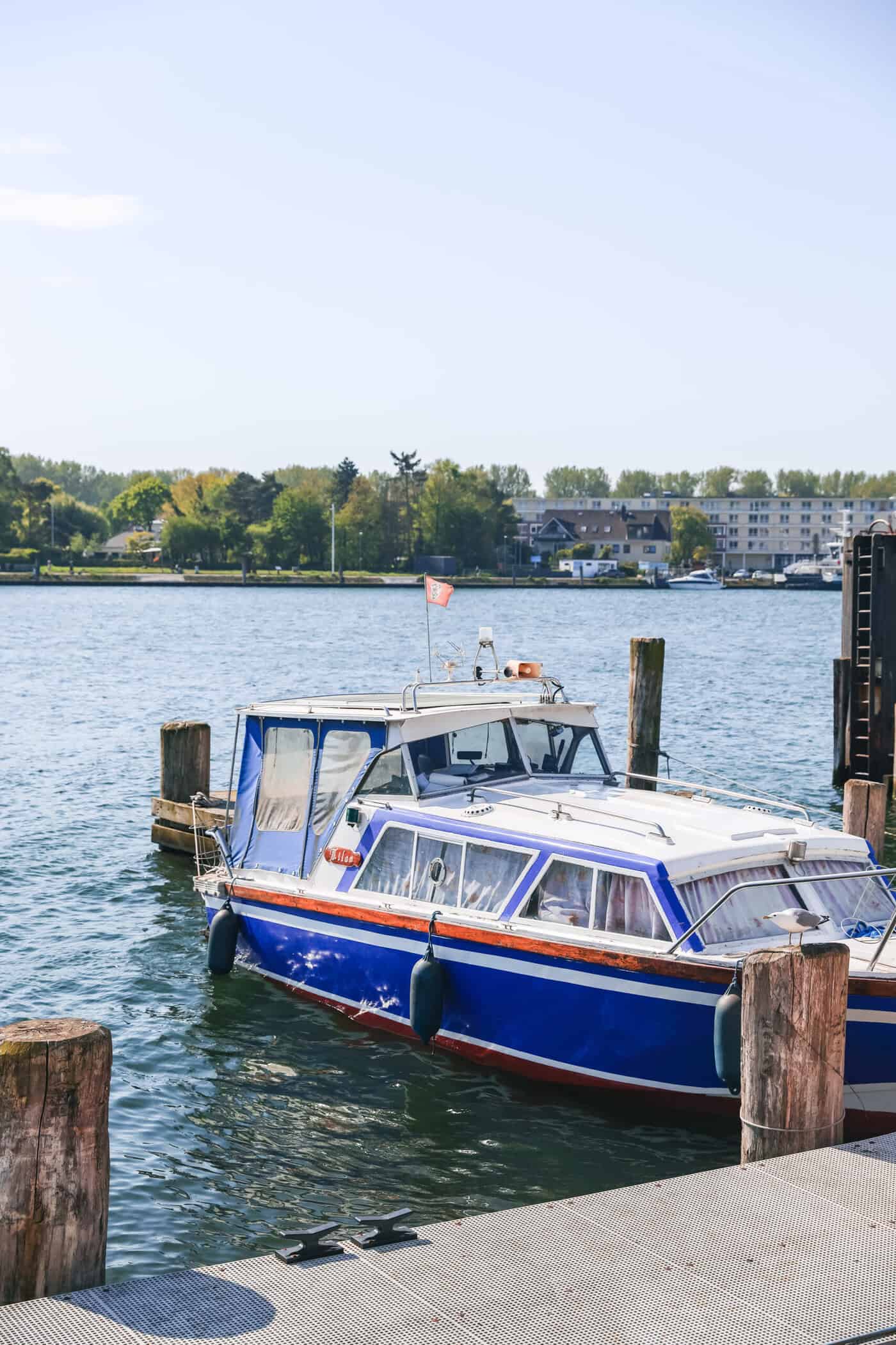 Ein blaues, kleines Boot an einem Anleger am Hafen von Travemünde
