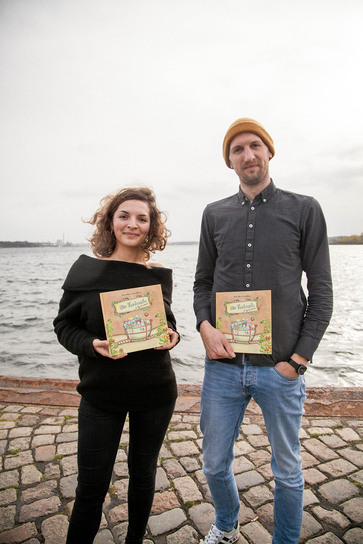 Lara und Florian mit dem Buch am Wasser