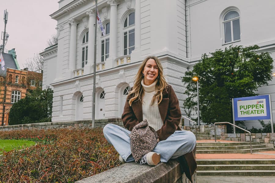 Finja T. sitzt auf den Treppen vor dem Stadttheater Rendsburg