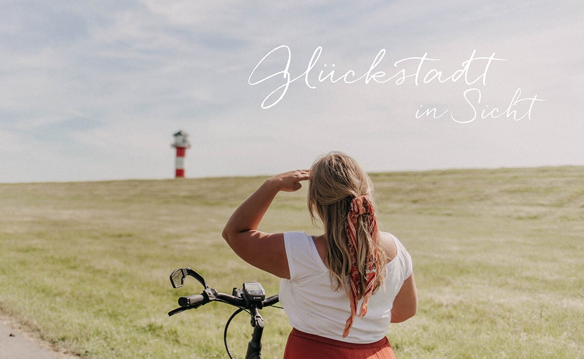 Mädchen auf Fahrrad vor dem Leuchtturm in Glückstadt