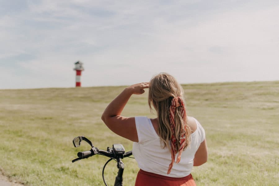 Mädchen auf Fahrrad vor Leuchtturm in Glückstadt