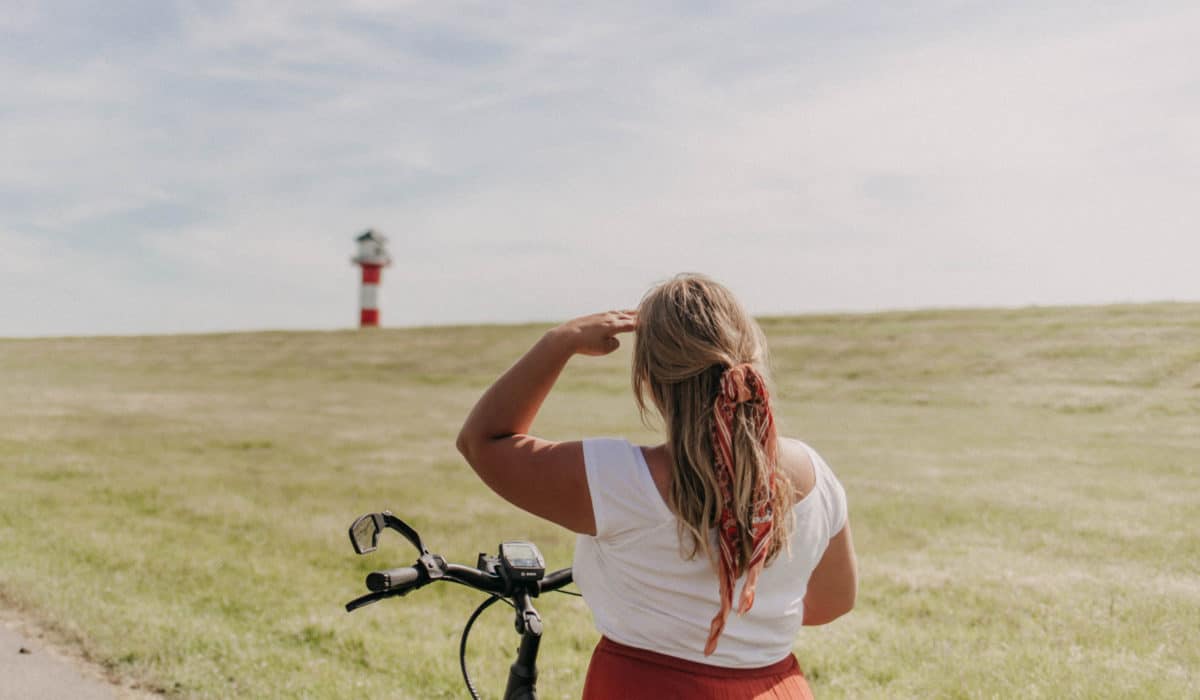 Mädchen auf Fahrrad vor Leuchtturm in Glückstadt