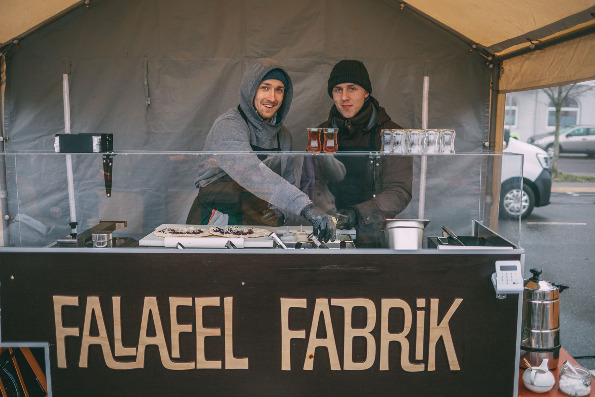 Zwei Verkäufer bereiten Falafel an ihrem veganen Falafelstand auf dem Kieler Wochenmarkt auf dem Blücherplatz zu