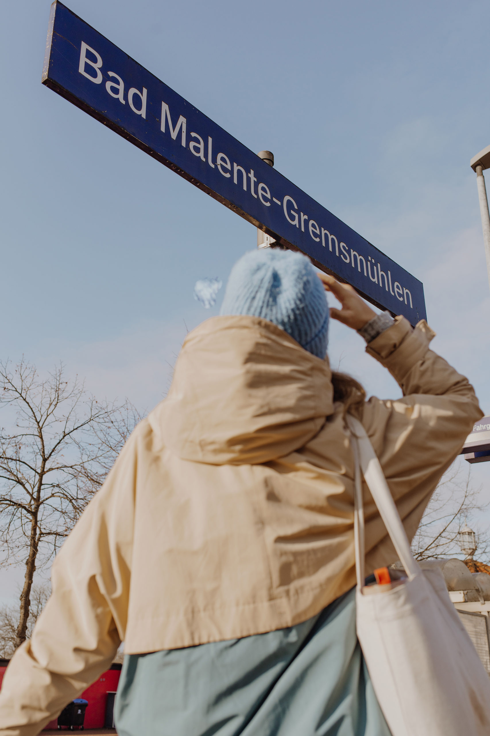 Sina vor Schild am Bahnsteig