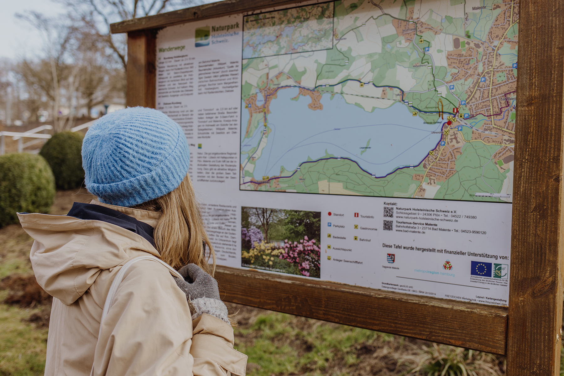 Sina steht vor Schild des Naturparks Malente