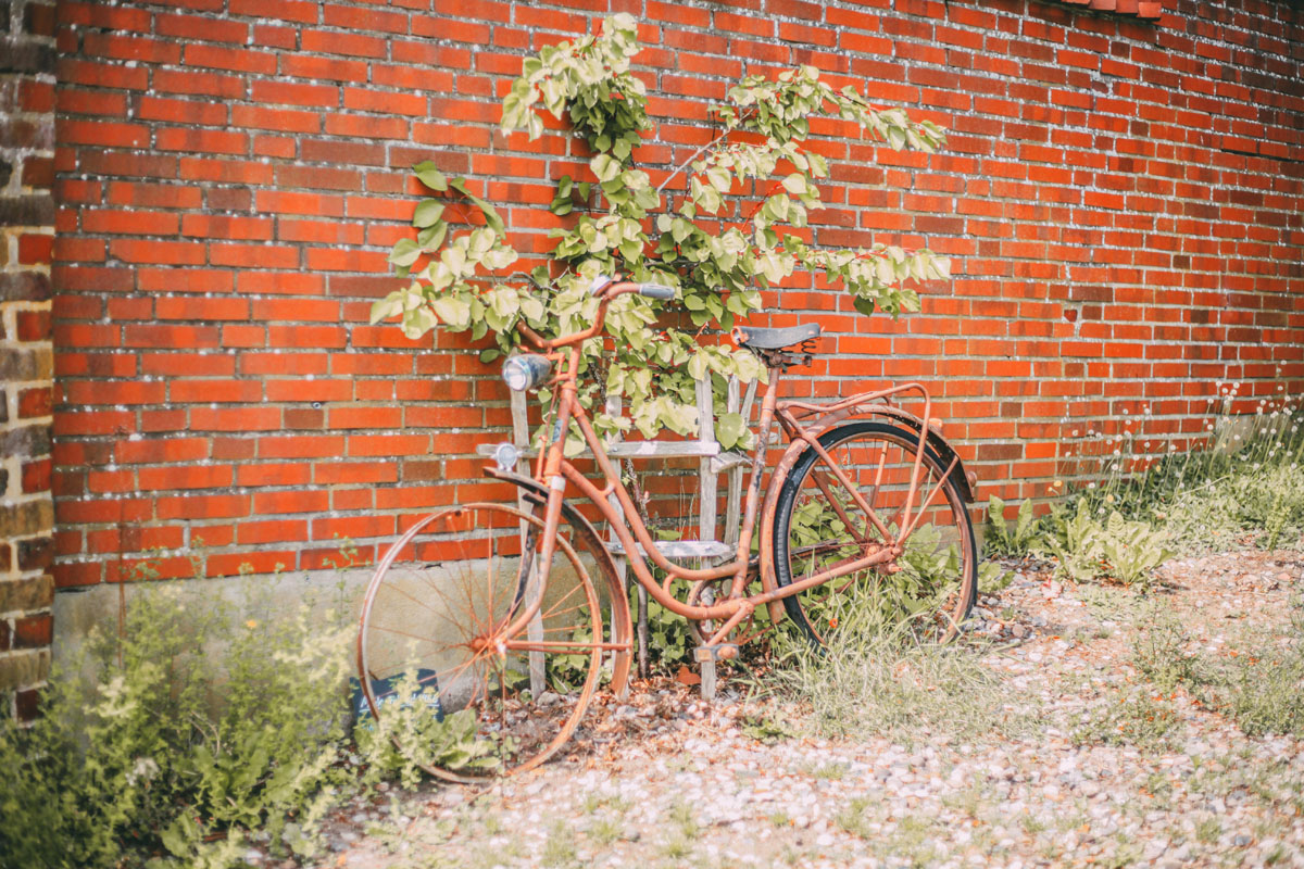 Ein rostiges Fahrrad lehnt an einer Hauswand