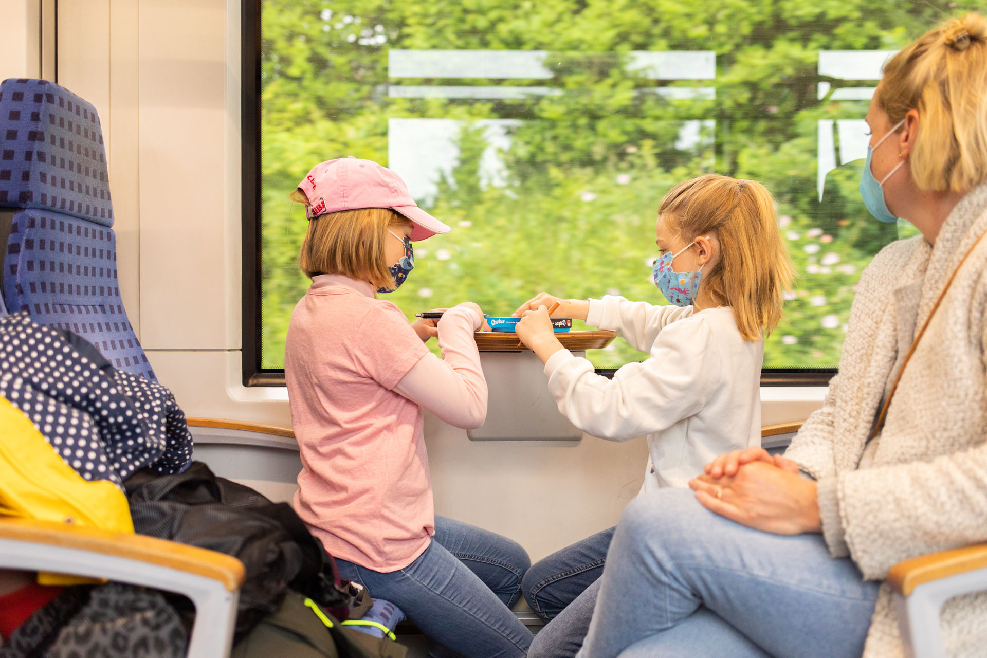 Die Mädchen sitzen im Zug und spielen ein Würfelspiel
