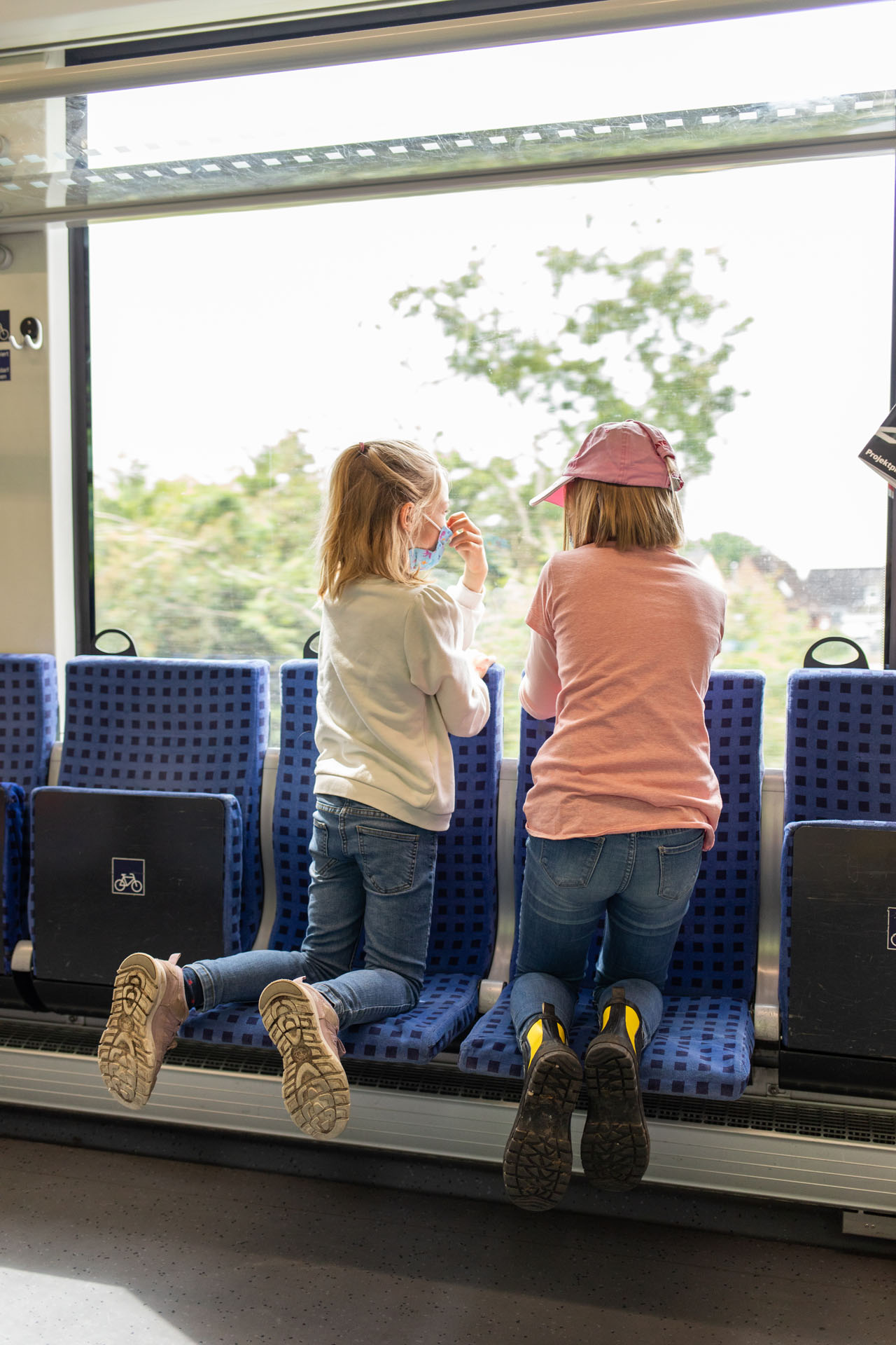 Helena und Jette auf Sitzbänken im Zug