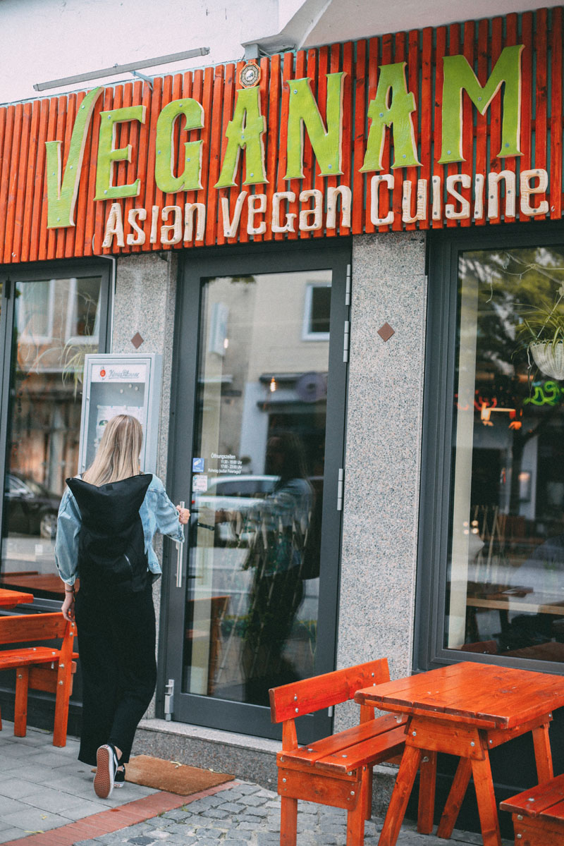 Finja steht vor der Tür vom Restaurant Veganam