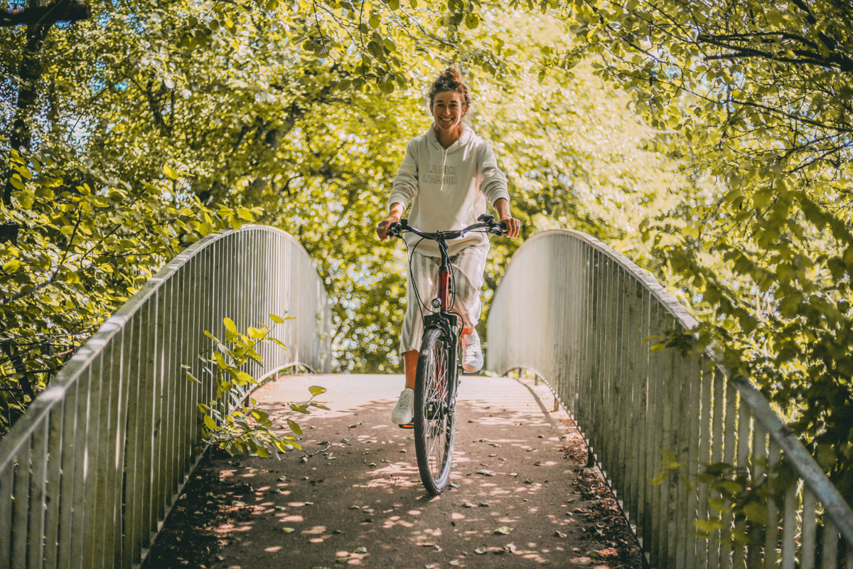 Mona fährt mit dem Fahrrad über eine Brücke