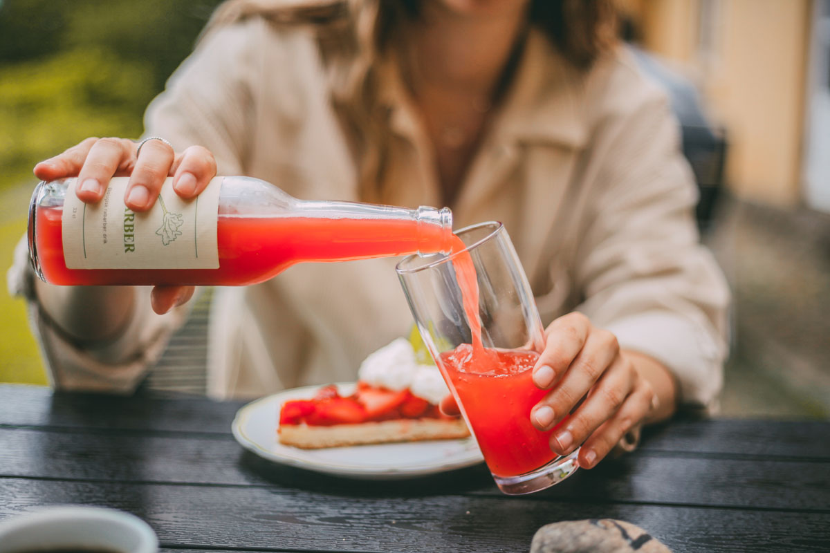 Finja schenkt Rhabarberschorle in ein Glas ein