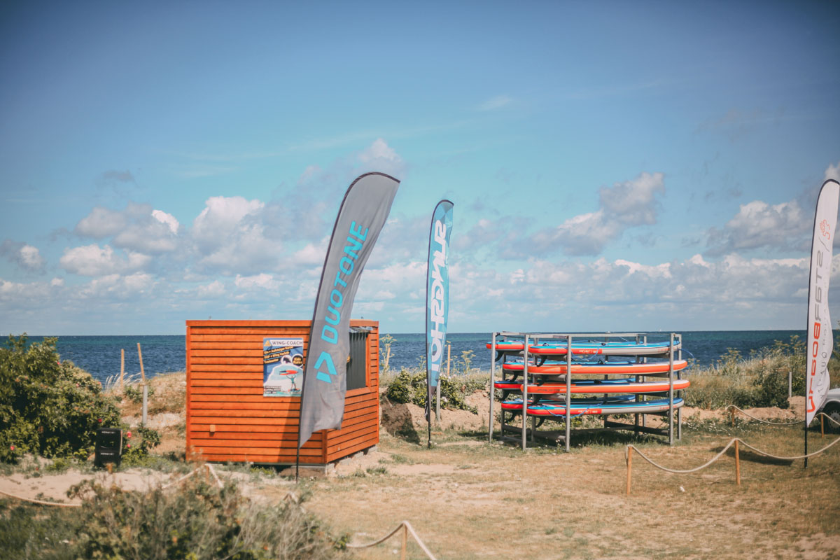 Ein Regal mit Surfbrettern und dem Meer im Hintergrund