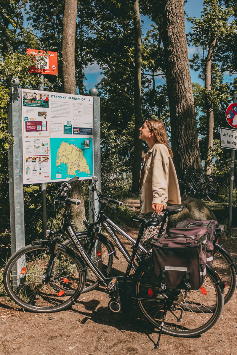 Finja lehnt an den Fahrrädern und liest das Schild