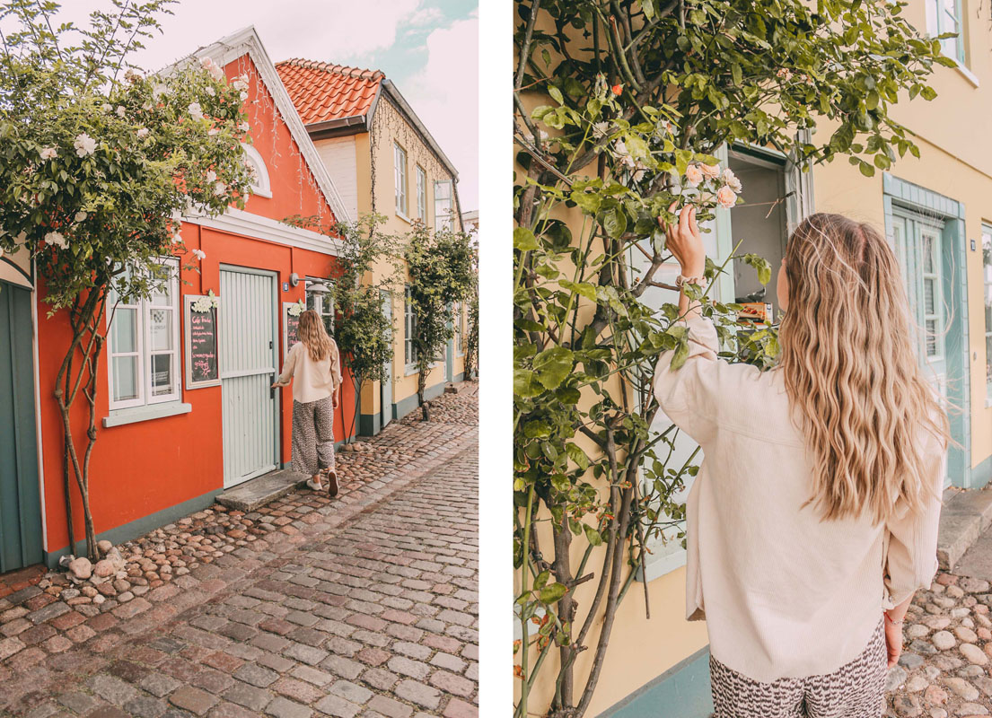 Finja steht vor einem kleinen Haus in einer Gasse in Burg auf Fehmarn