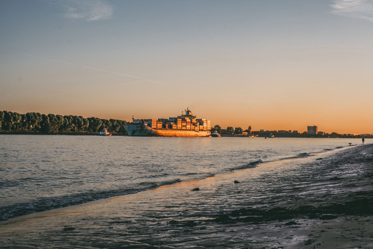 Ein Containerschiff auf der Elbe in der Abendsonne