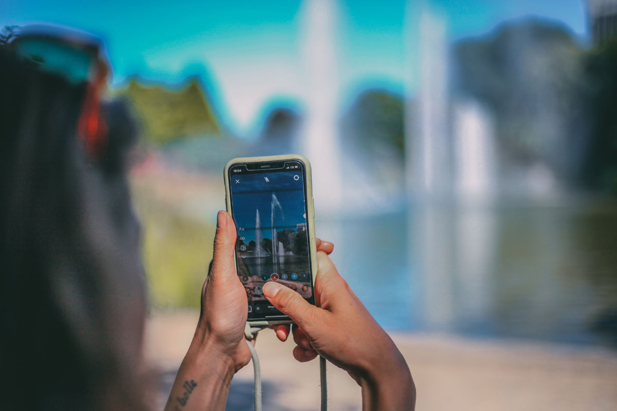 Mona fotografiert mit ihrem Handy die Wasserlichtspiele