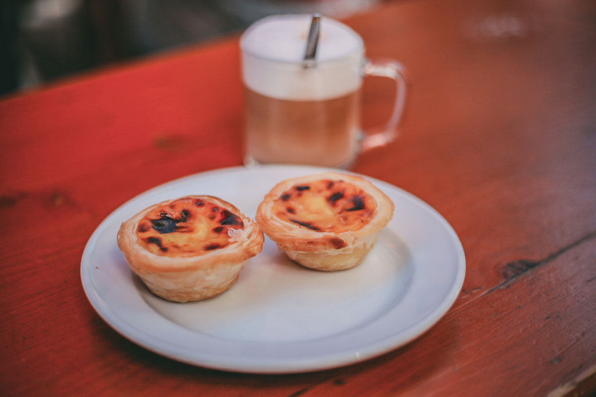 Ein Teller mit Pastel de Nata und ein Kaffee