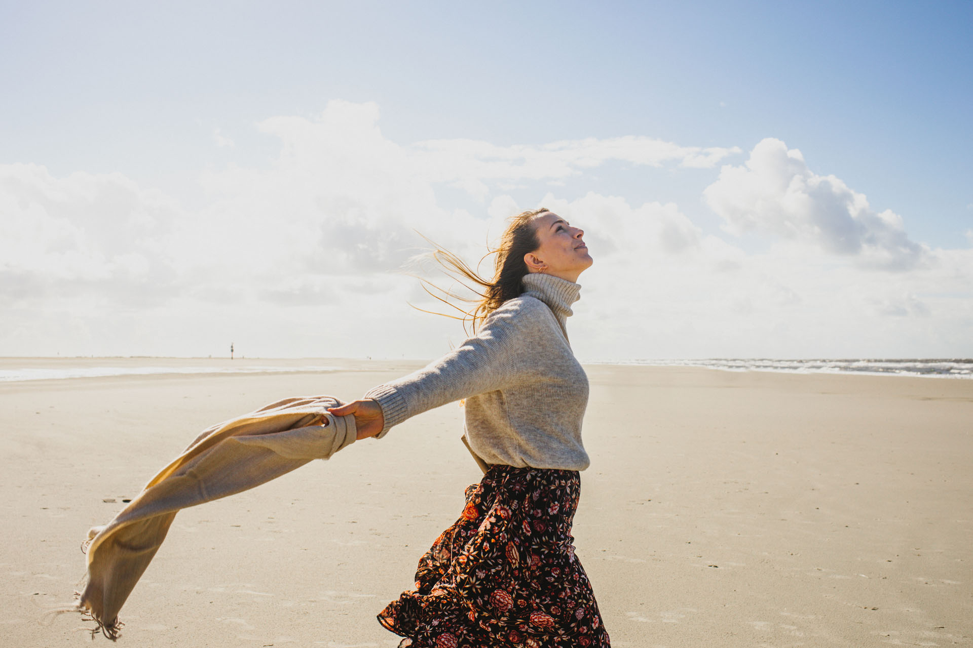 Finja steht mit ausgebreiteten Armen am Strand von St. Peter-Ording