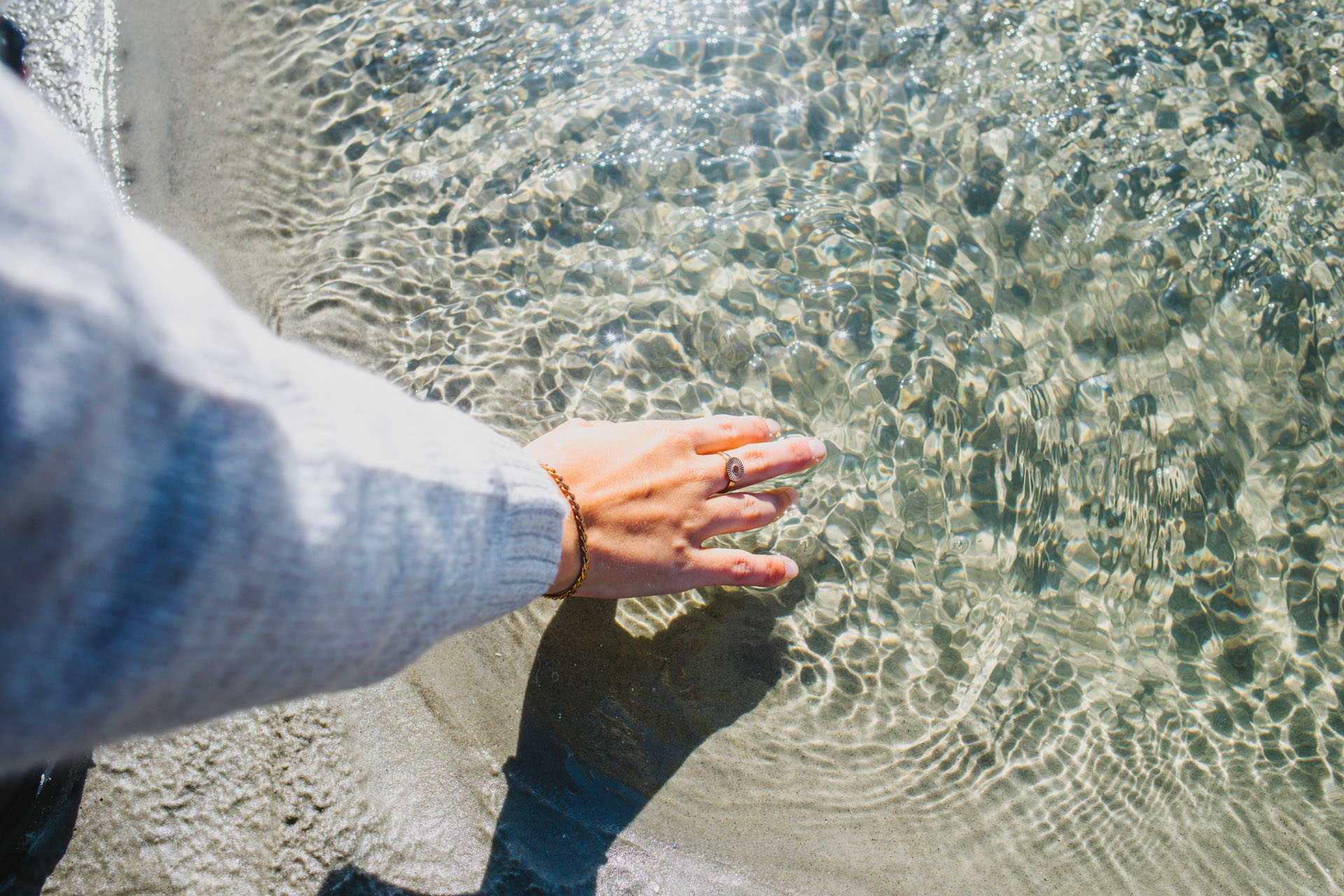 Finjas Hand berührt Meerwasser