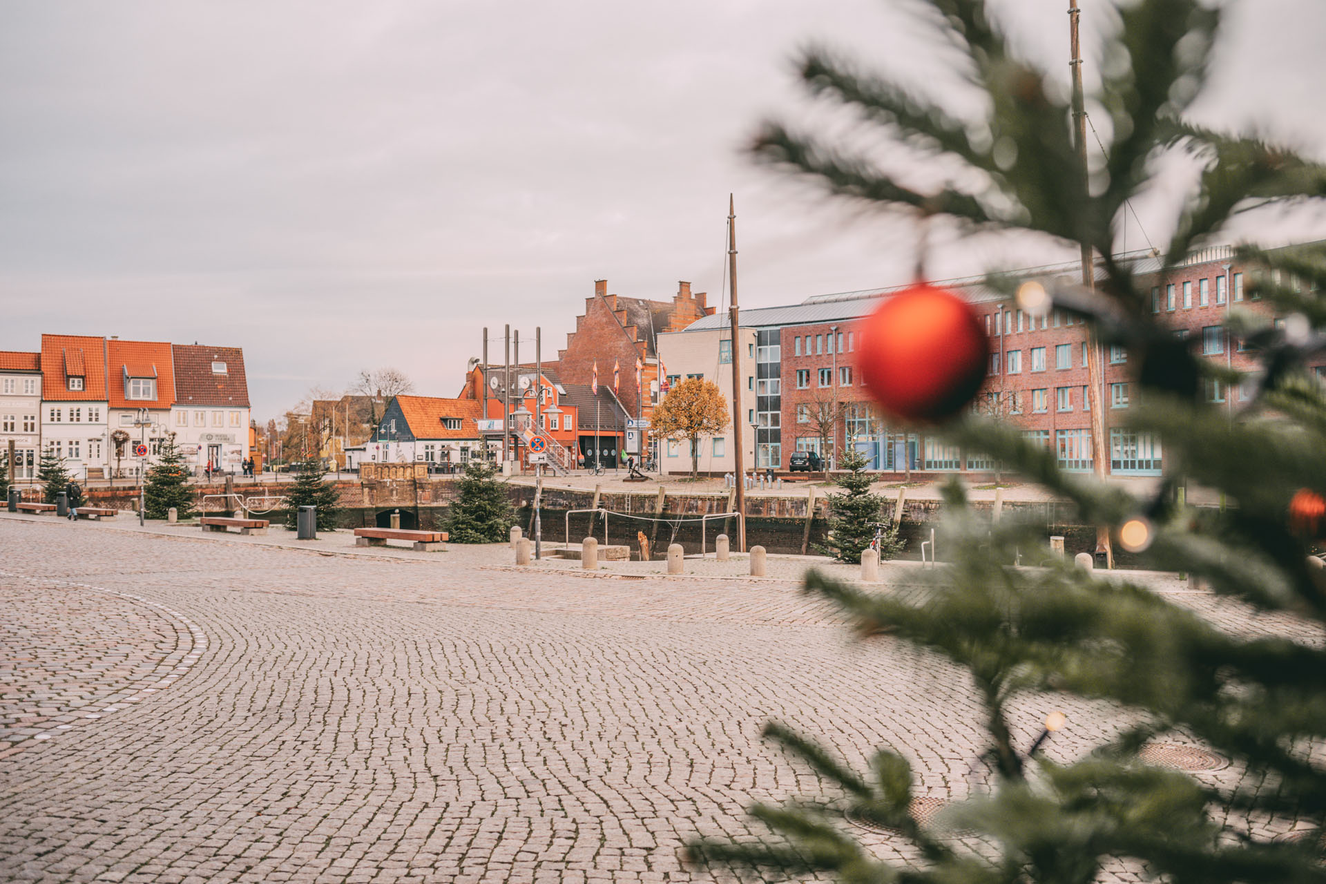 Der Hafen von Husum und ein Weihnachtsbaum mit einer Christbaumkugel dran.