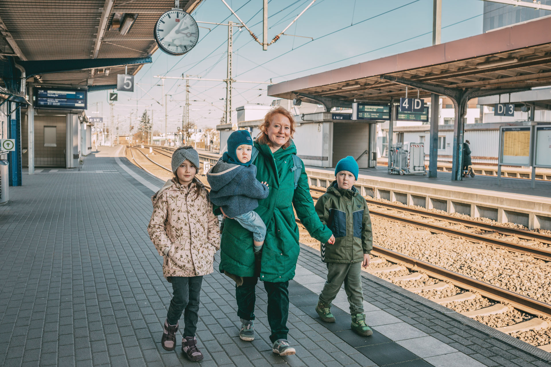 Eine Familie geht am Bahnsteig entlang