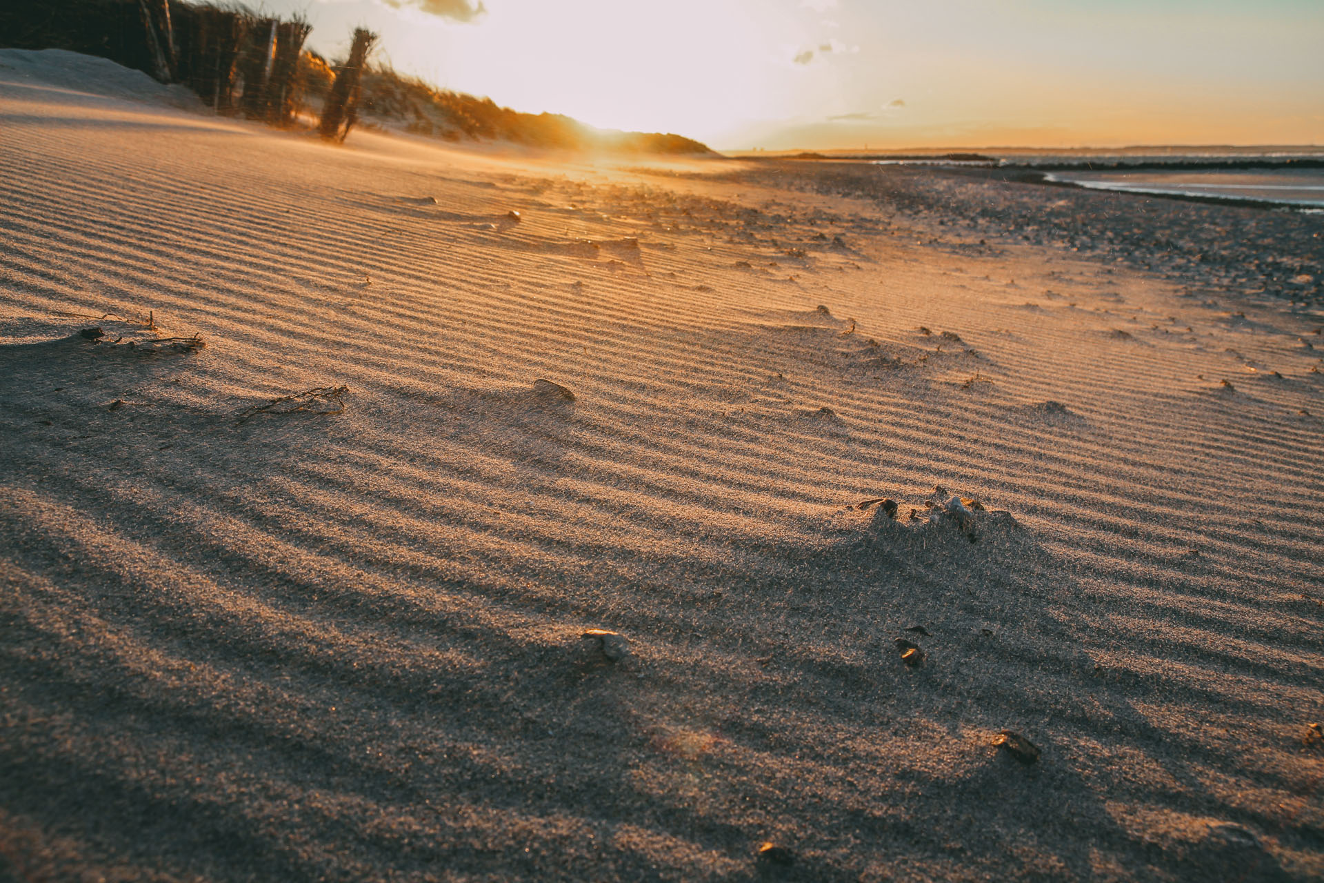 Sand und im Hintergrund die untergehende Sonne