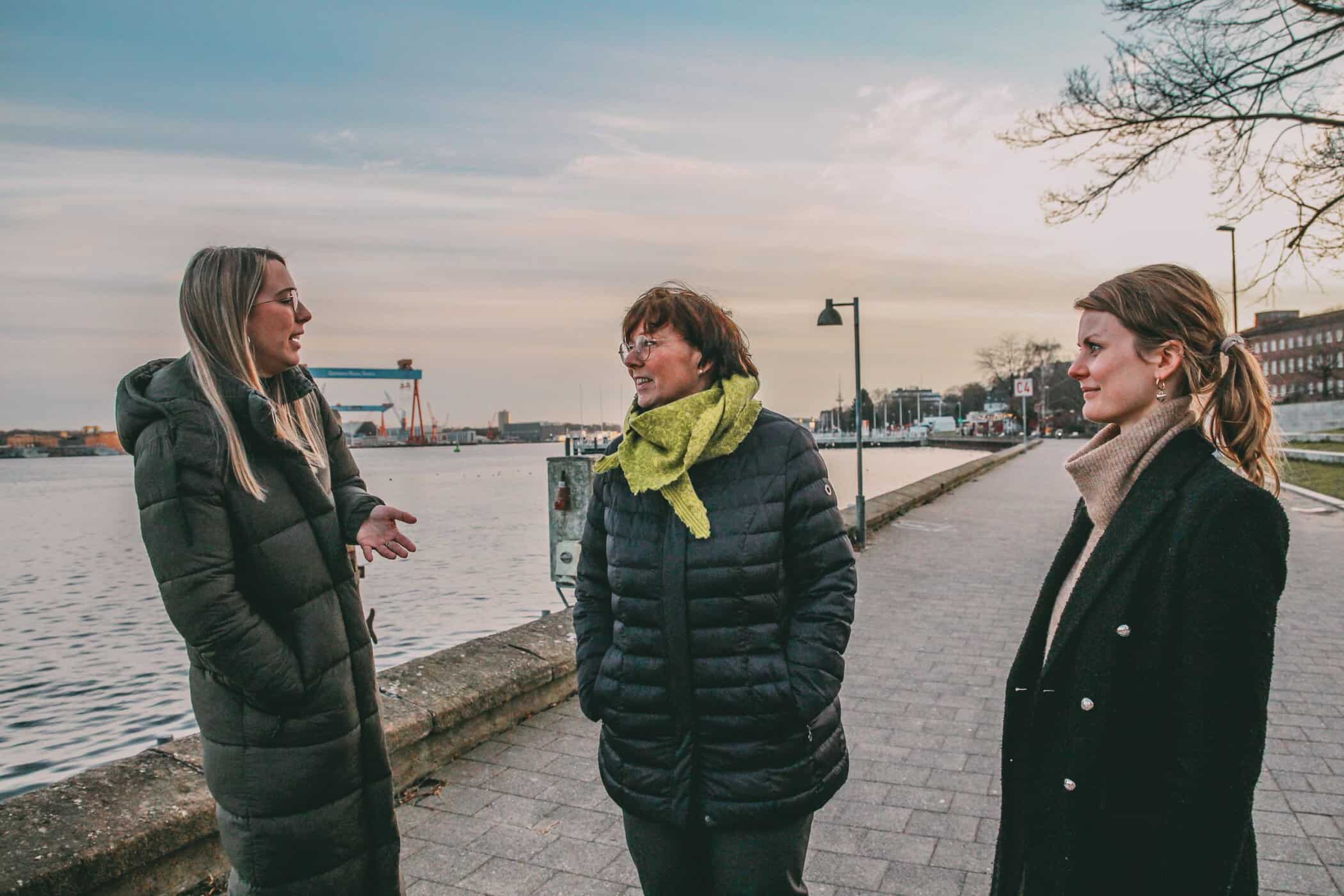 Finja, die Innenministerin und Maria Pape unterhalten sich an der Kiellinie über Internationale Wochen gegen Rassismus in Schleswig-Holstein