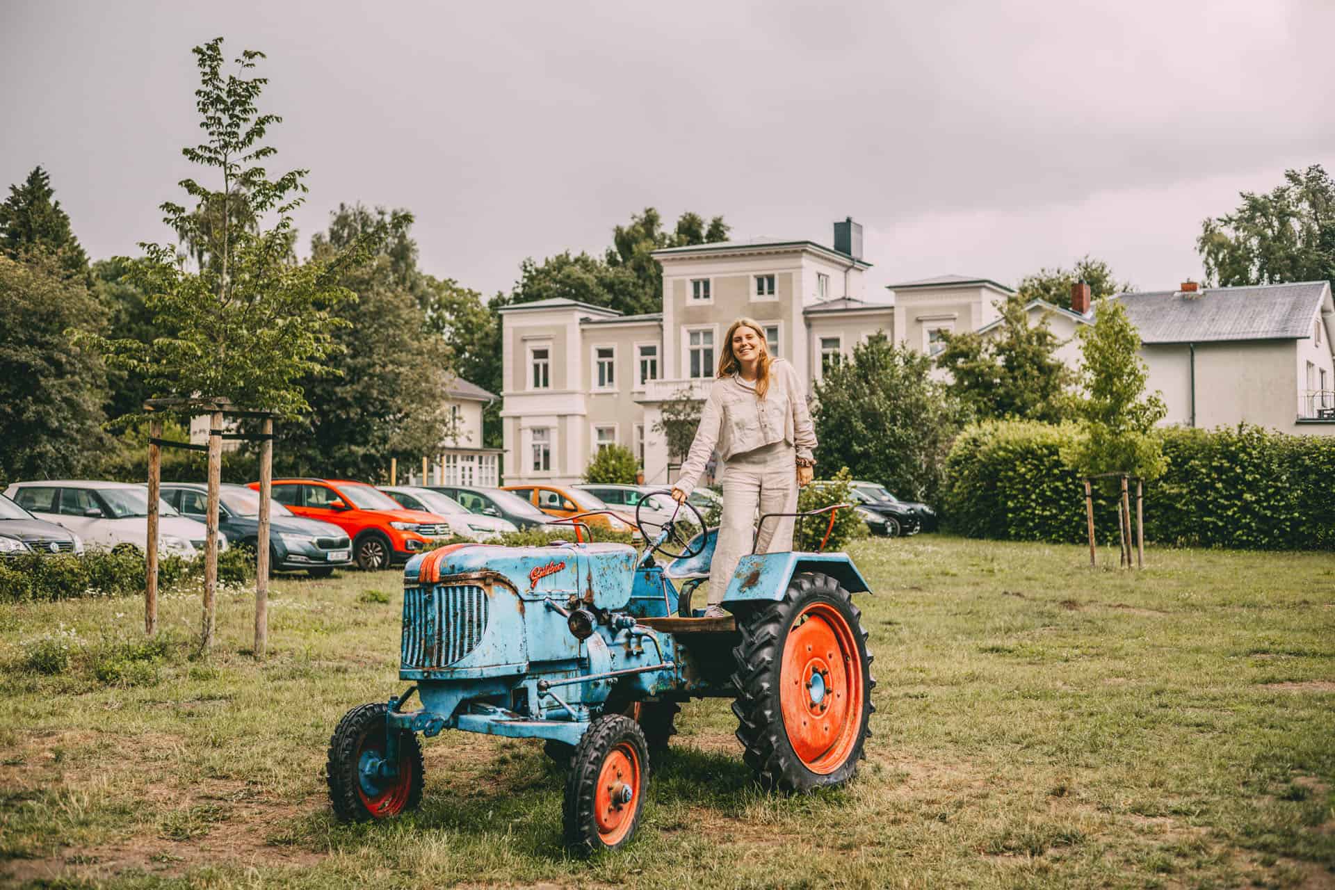 Blauer Traktor auf der Wiese vor dem Gutshaus auf Gut Wulksfelde