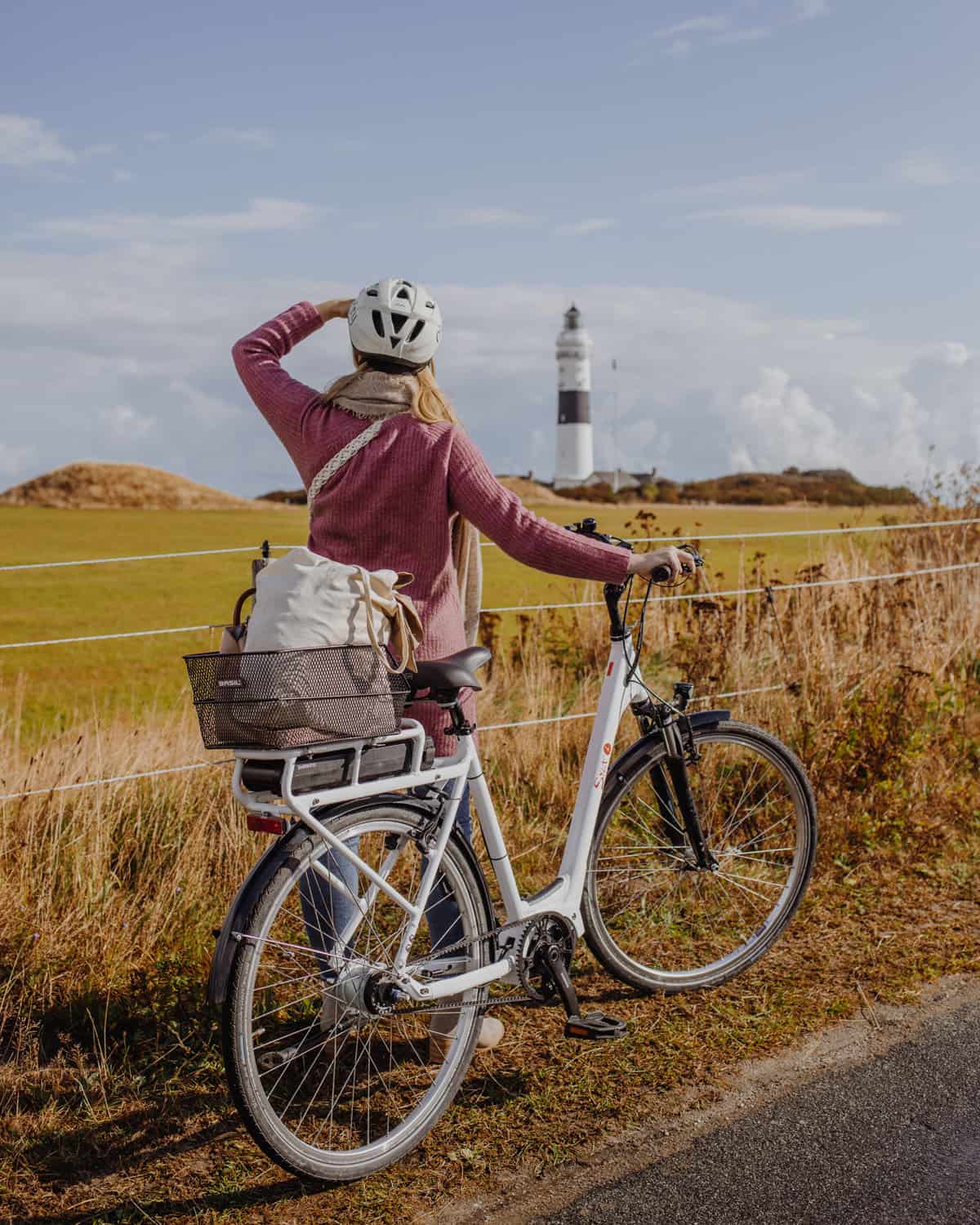 Achtsamkeit auf Sylt: Fahrradfahrerin vor dem Kampener Leuchtturm