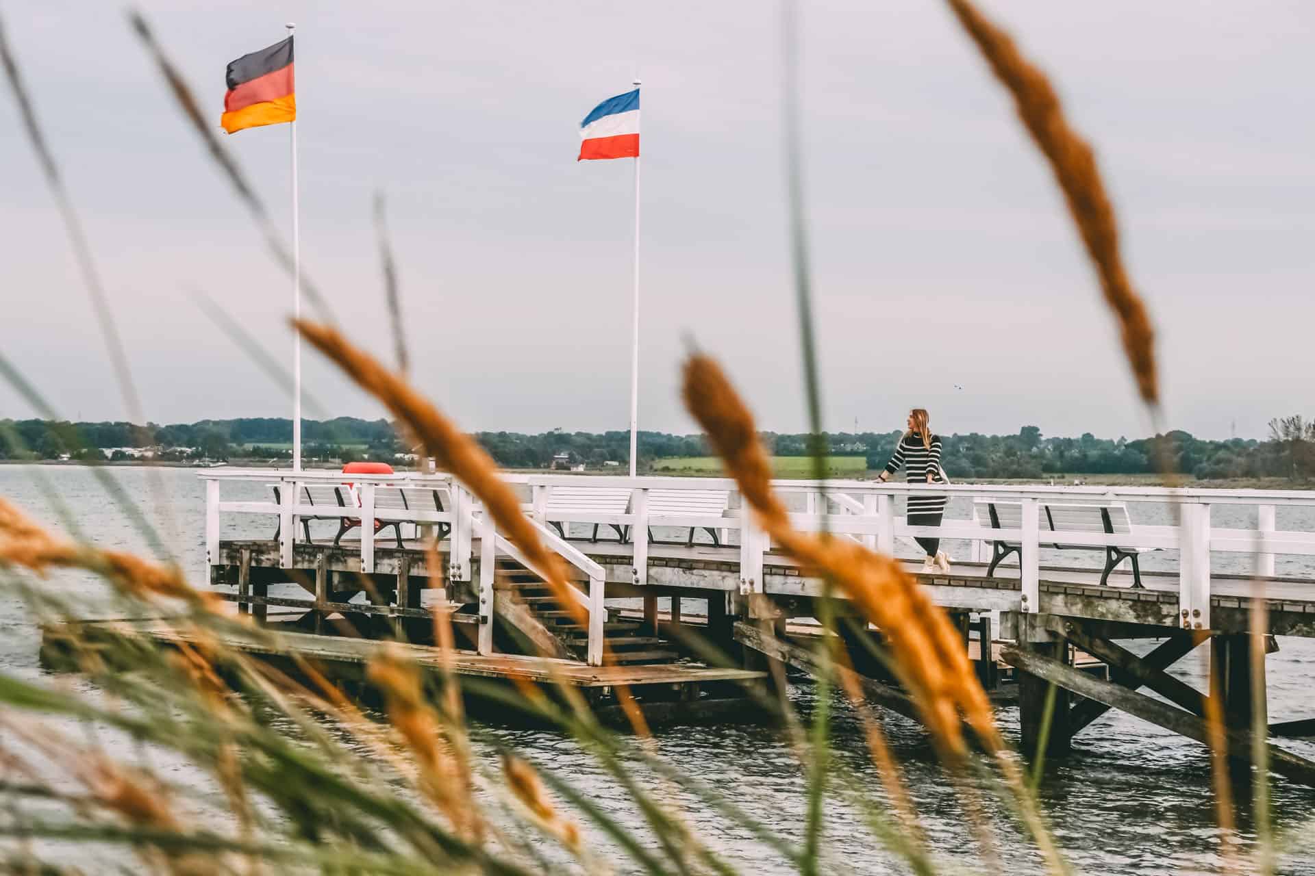 Finja steht auf einer Seebrücke in Hohwacht und blickt aufs Meer