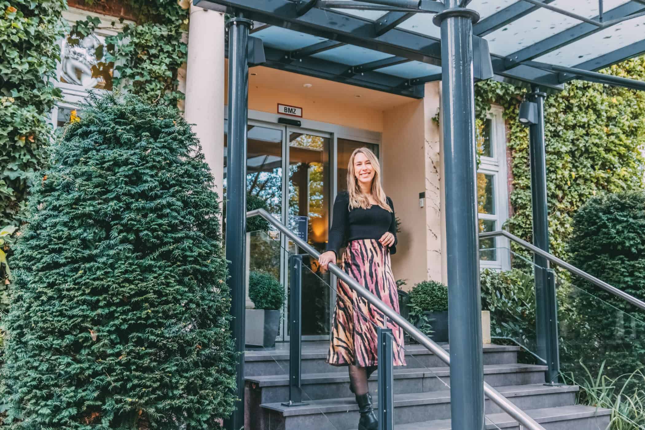 Finja steht auf der Treppe vom Haupteingang vom Hotel Kieler Kaufmann