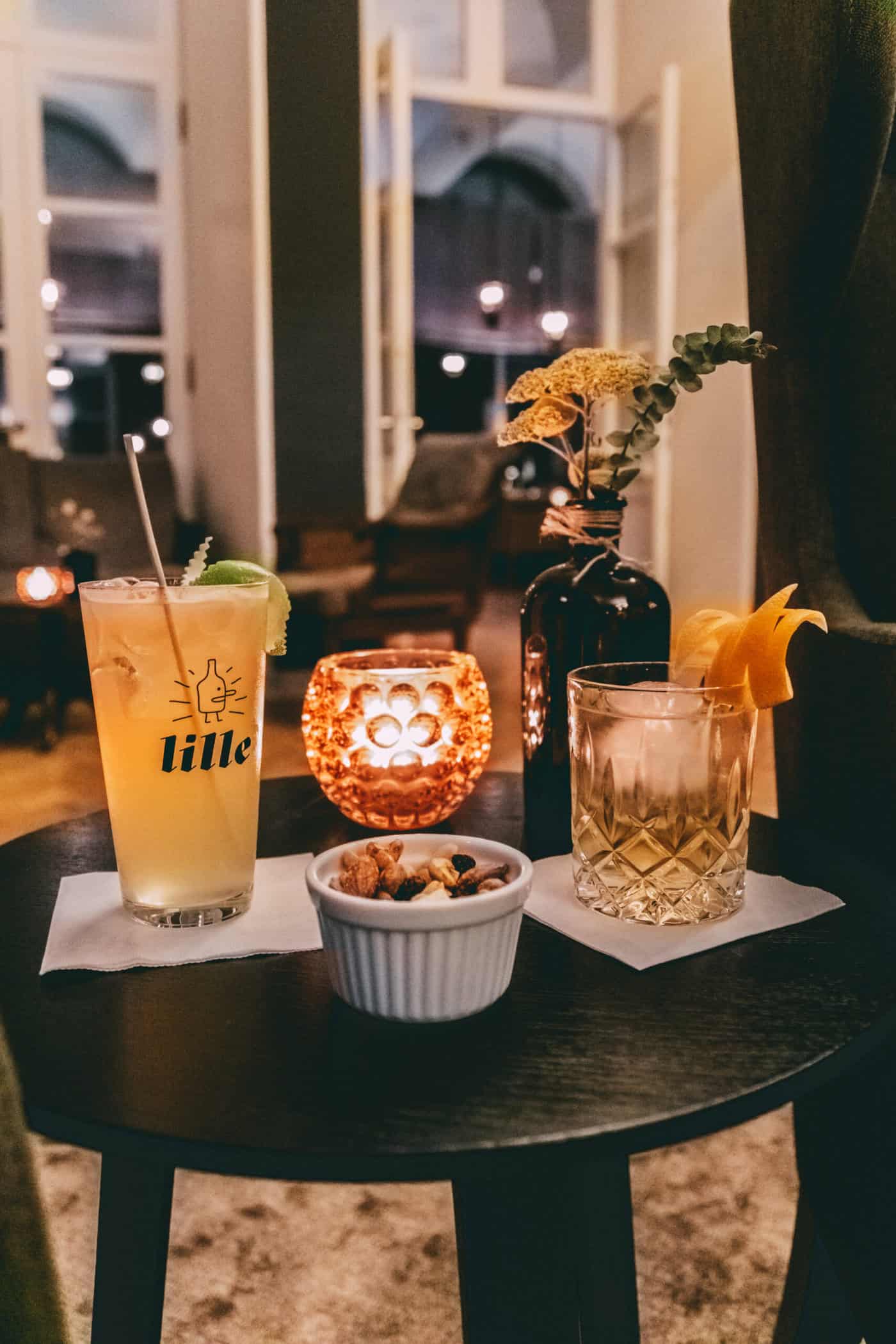 Cocktails, eine Nussmischung zum Snacken und Deko auf einem Hocker