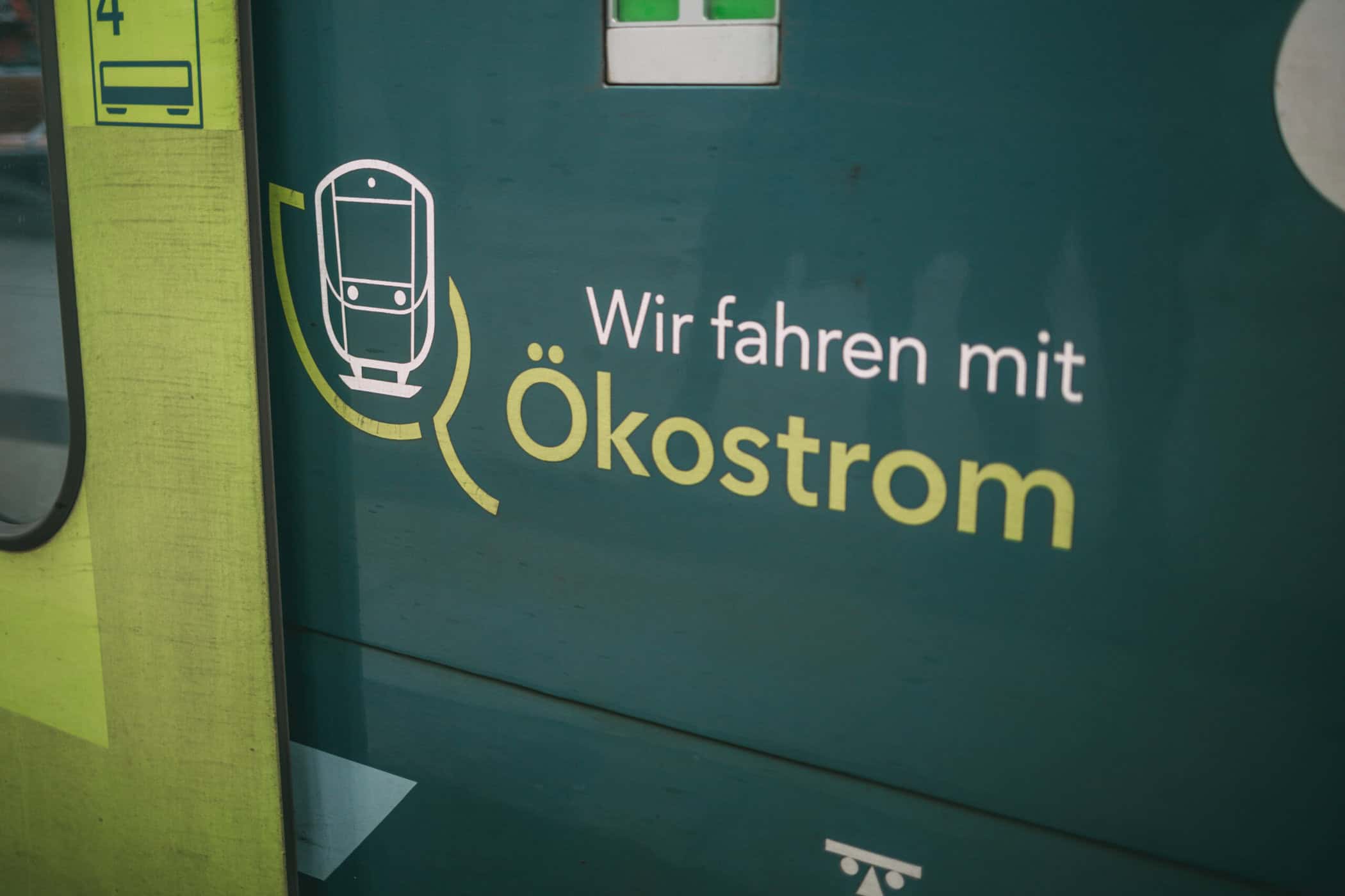 Nahaufnahme vom Zug mit Aufschrift „Wir fahren mit Ökostrom“