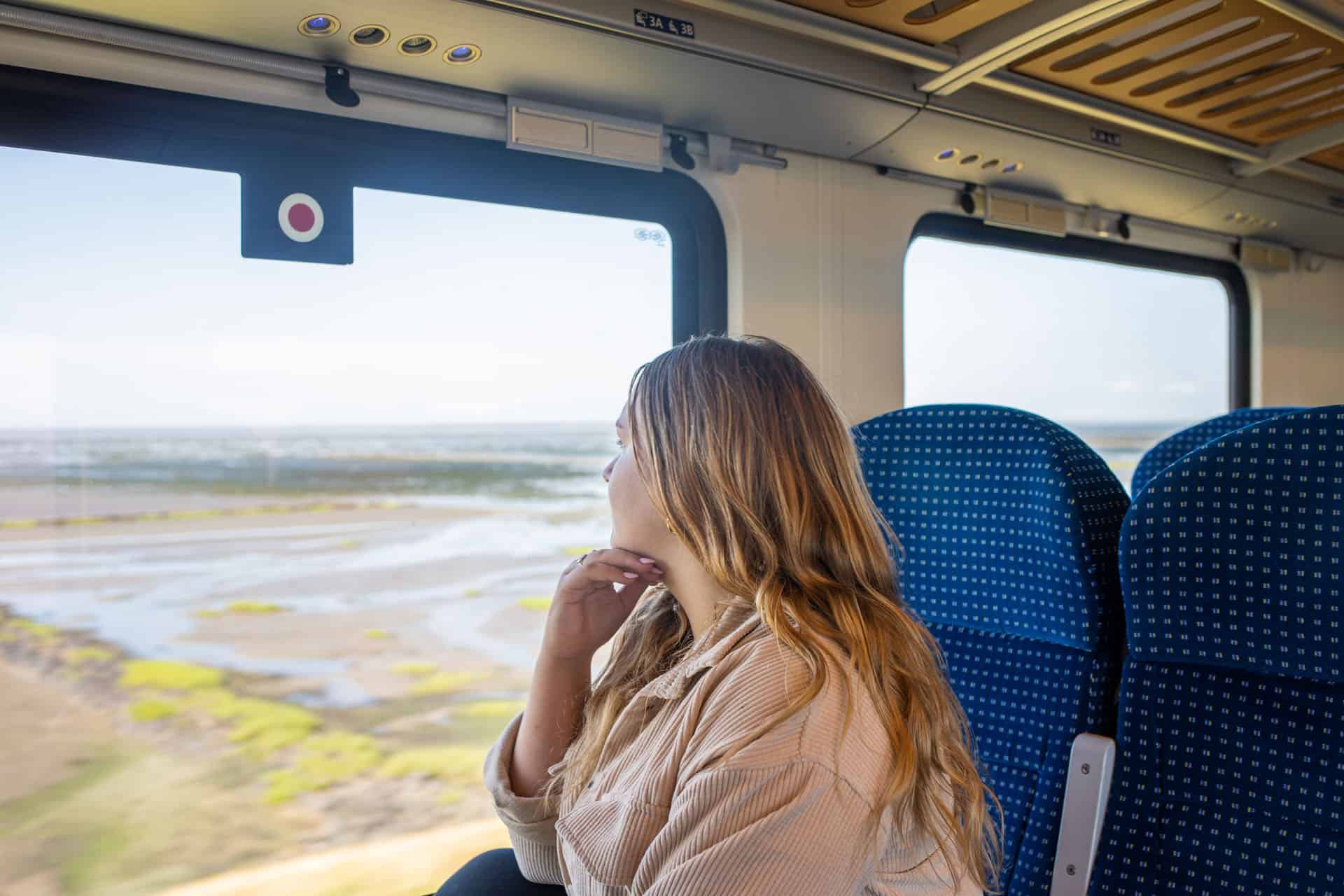 Mit dem Zug an die Nordsee: Sina Hoyer blickt aus dem Fenster der Regionalbahn der DB 