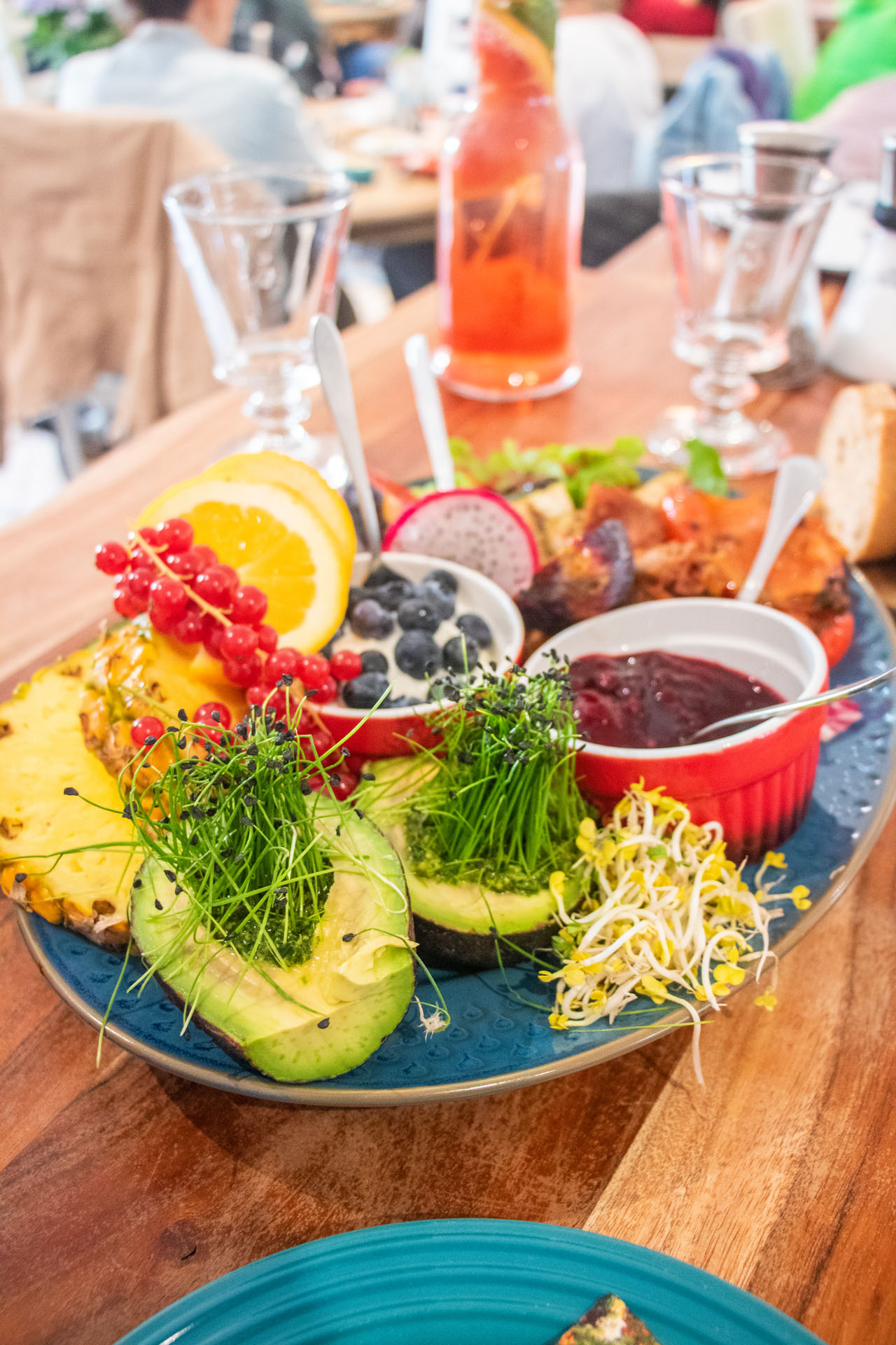 Frühstückskomposition im Künstlercafé Husum mit Avocado, Kresse, Obst, Joghurt und Grütze.