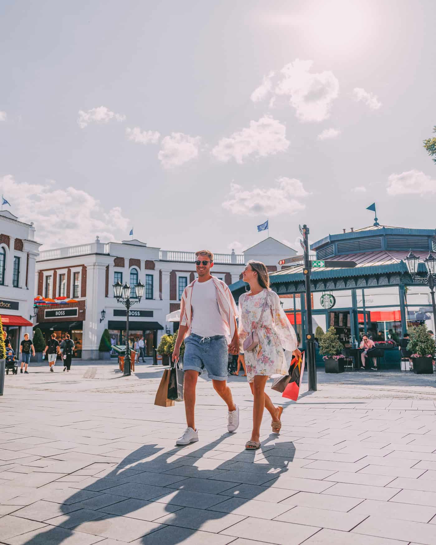 Eine Frau und ein Mann händchenhaltend beim Shopping im Designer Outlet Neumünster