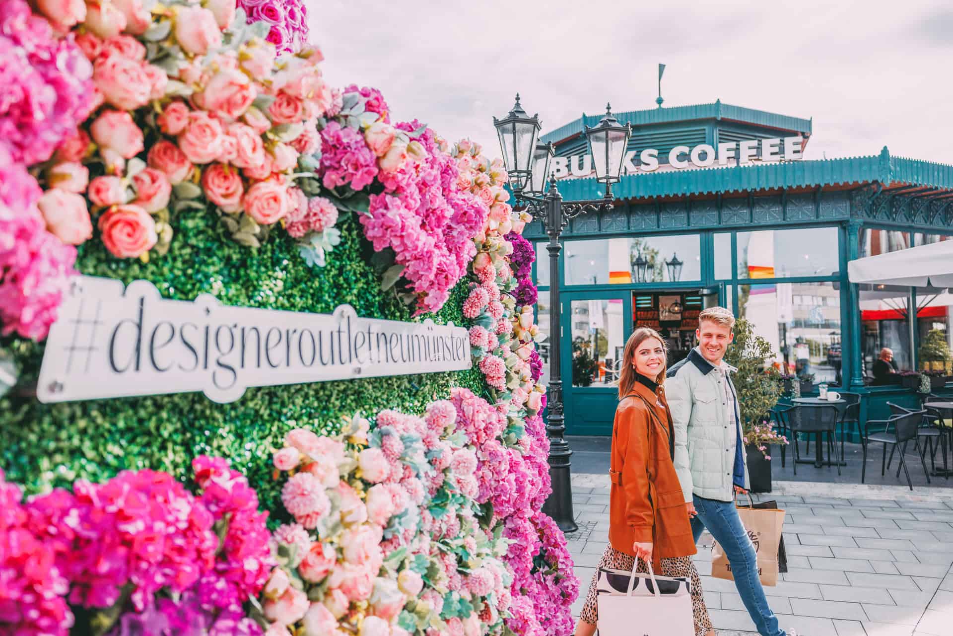 Eine Frau und ein Mann händchenhaltend beim Shopping im Designer Outlet Neumünster