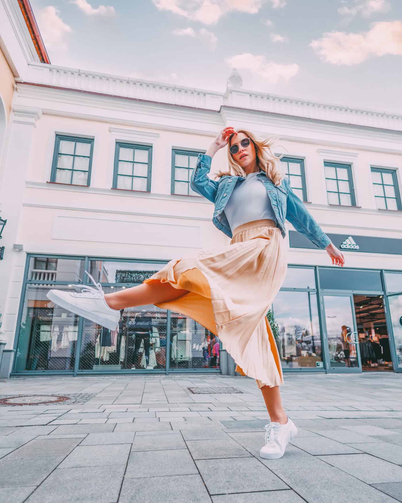 Eine Frau posiert schwungvoll im Designer Outlet Neumünster