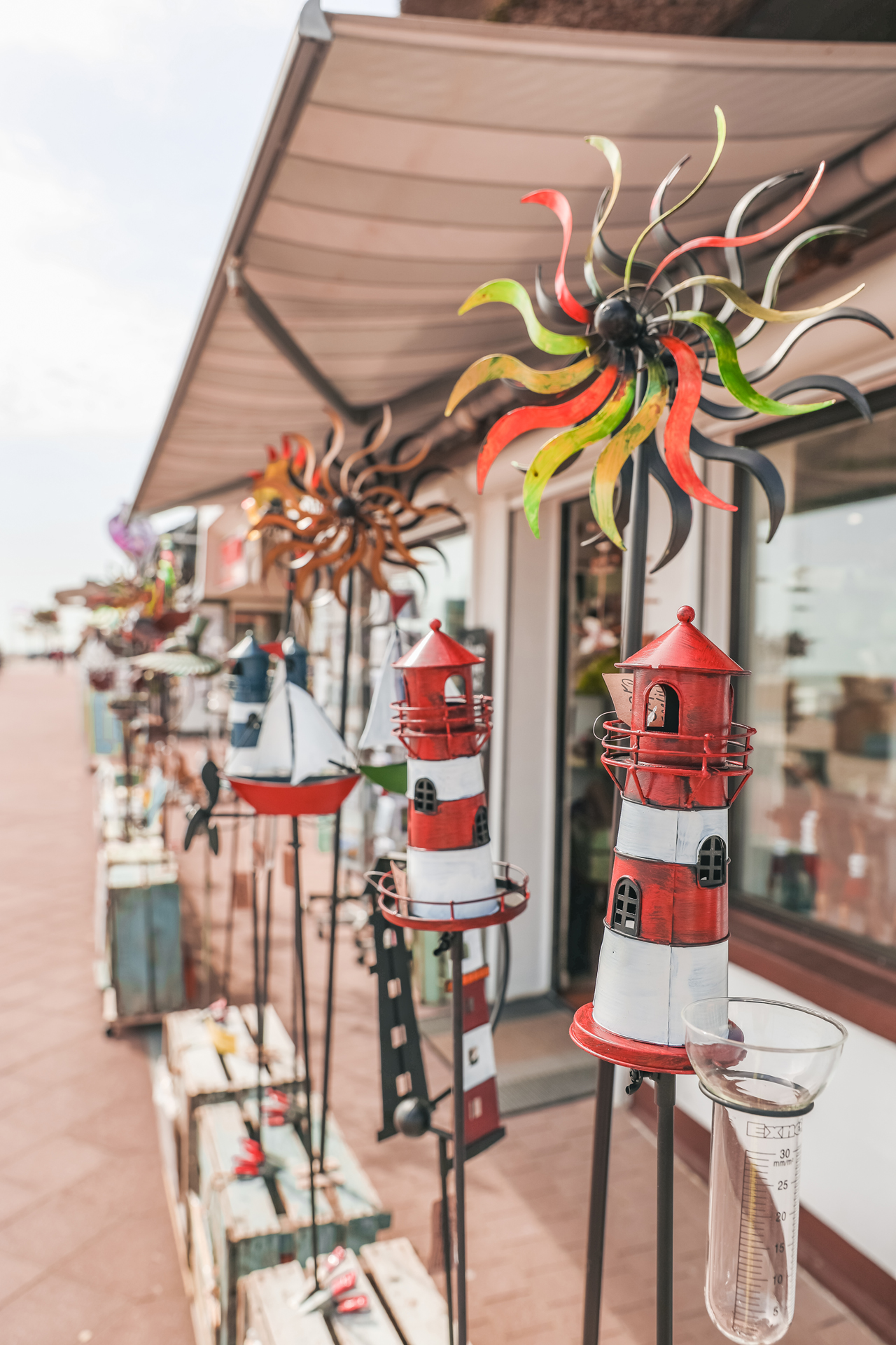 Windspiele und Deko-Leuchttürme vor einem Geschäft an der Strandpromenade von Dahme